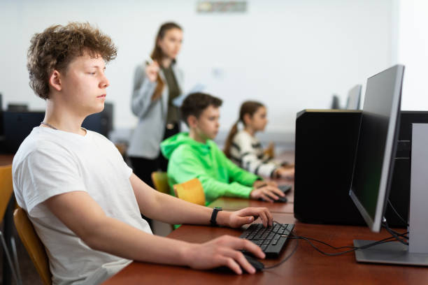 teenager boy using pc during computer science lesson - 电竞教育 個照片及圖片檔